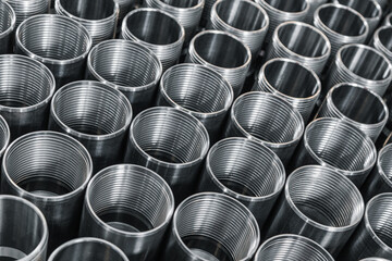 Closeup pattern of shiny circular precision stainless steel industrial machine parts arranged in rows on pallet. Steel products to automotive industry.Billet obtained on lathe from steel and cast iron