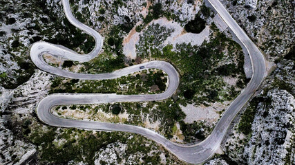 A top-down aerial view on mountainous curvy road Nus de Se Calobra, famous and dangerous zig zag road in the valley leading to the coast of Mallorca Island.