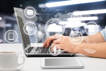 Male hands with the phone on a laptop on office table