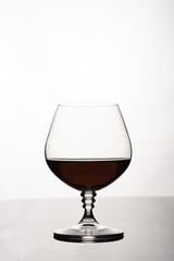 Glass of cognac on white background