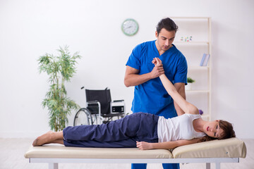 Injured woman visiting young male doctor osteopath