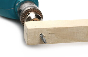 Electric power drill bit and hole with wood shavings isolated on white background