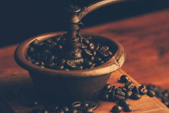 Molinillo de caf&eacute; antiguo de madera con granos de caf&eacute; dentro y a punto de moler. macro