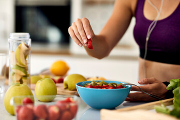 Close-up of female athlete eating fruit salad.