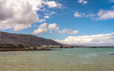 White sand and black lava rocks at Caleton Blanco beach, Lanzarote, Canary Islands, Spain. Volcanic...