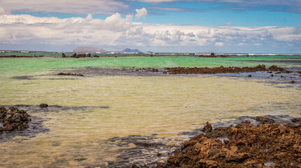 White sand and black lava rocks at Caleton Blanco beach, Lanzarote, Canary Islands, Spain. Volcanic...