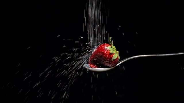 macro de fresa roja con az&uacute;car en chorro en c&aacute;mara lenta