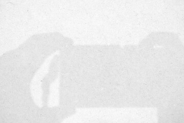 Shadow of Hand holding Camera on Plywood Texture Background.