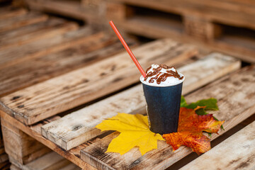 Autumn, fall leaves, hot steaming cup of coffee on a wooden table background.