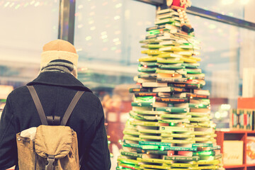 Obraz premium man in a gray coat in a bookshop. The concept of self-education. toned