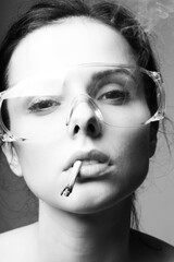 beautiful young girl in goggles with a cigarette