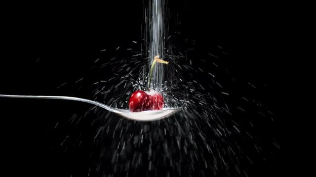 Cereza roja con rabillo le cae azucar en c&aacute;mara lenta
