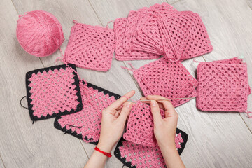 Female hands holding knitting accessories and knitting yarn. Needlework.