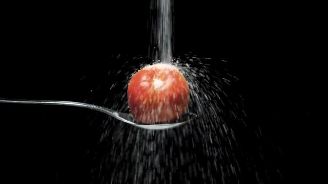 slow motion c&aacute;mara lenta de az&uacute;car cayendo sobre manzana en fondo negro