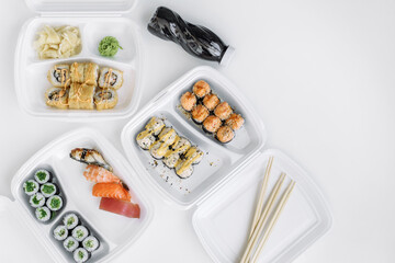  Sushi and rolls set in a plastic box (top view). Delivery service consept.