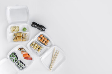  Sushi and rolls set in a plastic box (top view). Delivery service consept.