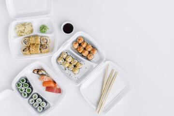  Sushi and rolls set in a plastic box (top view). Delivery service consept.