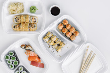  Sushi and rolls set in a plastic box (top view). Delivery service consept.
