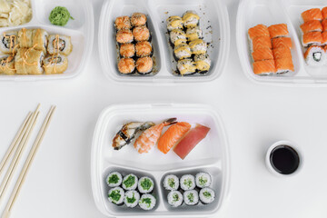 Assorted sushi and rolls mix in a plastic box (top view). Delivery service consept.
