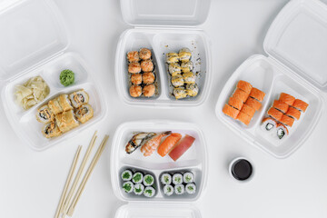  Sushi and rolls set in a plastic box (top view). Delivery service consept.