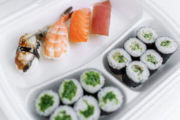 Sushi and rolls in a plastic box close up. Delivery service consept.
