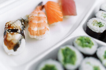 Sushi and rolls in a plastic box close up. Delivery service consept.