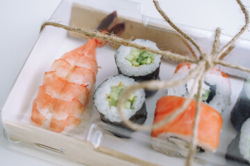Sushi and rolls on take away recycling eco paper box. Close up. Delivery food concept.