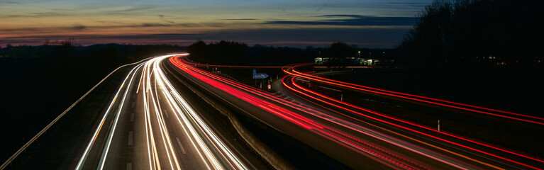Autobahn bei Nacht mit Langzeitbelichtung. Auto LED Lichter bei Sonnenuntergang 