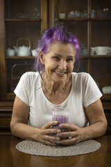 senior woman drinking a smoothie at home in the dining room - 353936186