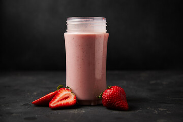 Strawberry smoothie in a glass against a dark background
