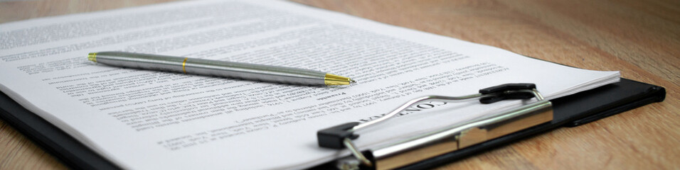 Business concept. Pen lying on a contract, wide angle view.