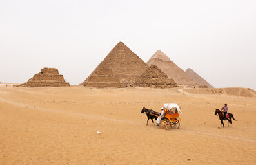 GIZA, EGYPT, APRIL 20: Tourists travelling in desert and dunes to see the Pyramids at Giza complex, Cairo, Egypt on April 20, 2018