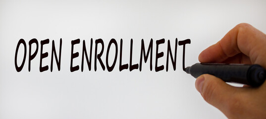 Hand writing 'open enrollment', isolated on beautiful white background. Concept.