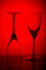 Two Empty wine glasses isolated on red background.