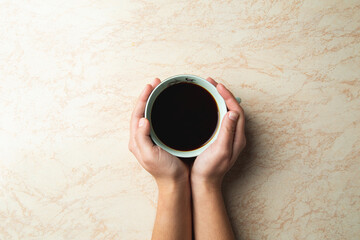 a top view of a hands holding a cup of coffee
