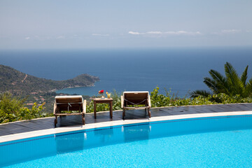 Swimming pool with amazing sea view. Sun beds, drinks and Mediterranean sea
