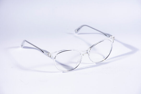 Lentes transparentes con patas de metal sobre fondo blanco