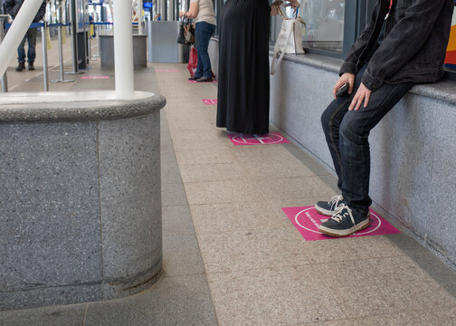 People (men And Women) In A Line Or Queue At The Bus Station Obeying A Social Distance Rule During The Quarantine Or Epidemic Or Lockdown