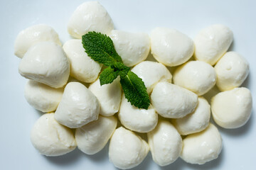 tasting cheese. mozzarella cheese balls on a white plate.