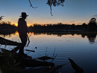 A silhouette of a man fishing