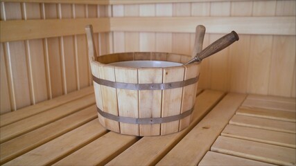 Fototapeta na wymiar Wooden dishes in the sauna. Brooms with dried herbs in a wooden bath. Relaxation concept.