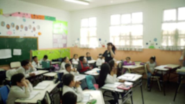 Blurred Teacher and Students in Classroom. 