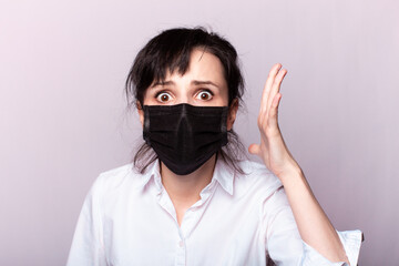beautiful girl in a white shirt and black medical mask