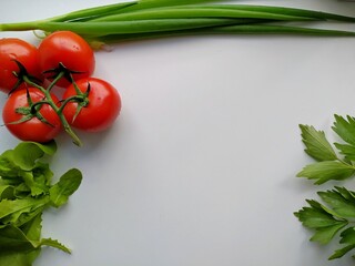 freshly cut celery, tomatoes, green onion. leaf salad isolated on a white table