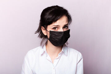 beautiful girl in a white shirt and black medical mask
