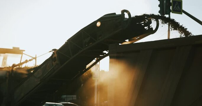 Road construction works on sunset. Asphalt removing with milling grinding