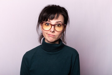 Fototapeta premium girl in a green turtleneck, glasses, portrait on a gray background