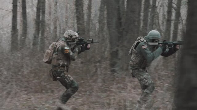 soldiers run through the forest