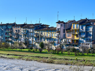 View of the picturesque coloured houses on the river Parma from Ponte di Mezzo, in Parma, on a sunny winter day
