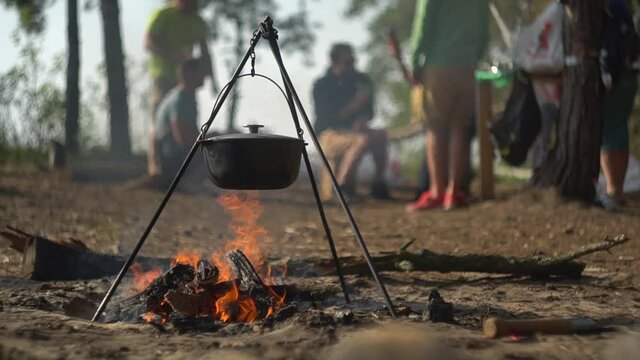 cauldron at the stake. camping in the wood. cooking on the fire. field kitchen. in a pot coming to a boil. a fire built up under a wash pot for scalding water. soup in his bowl.